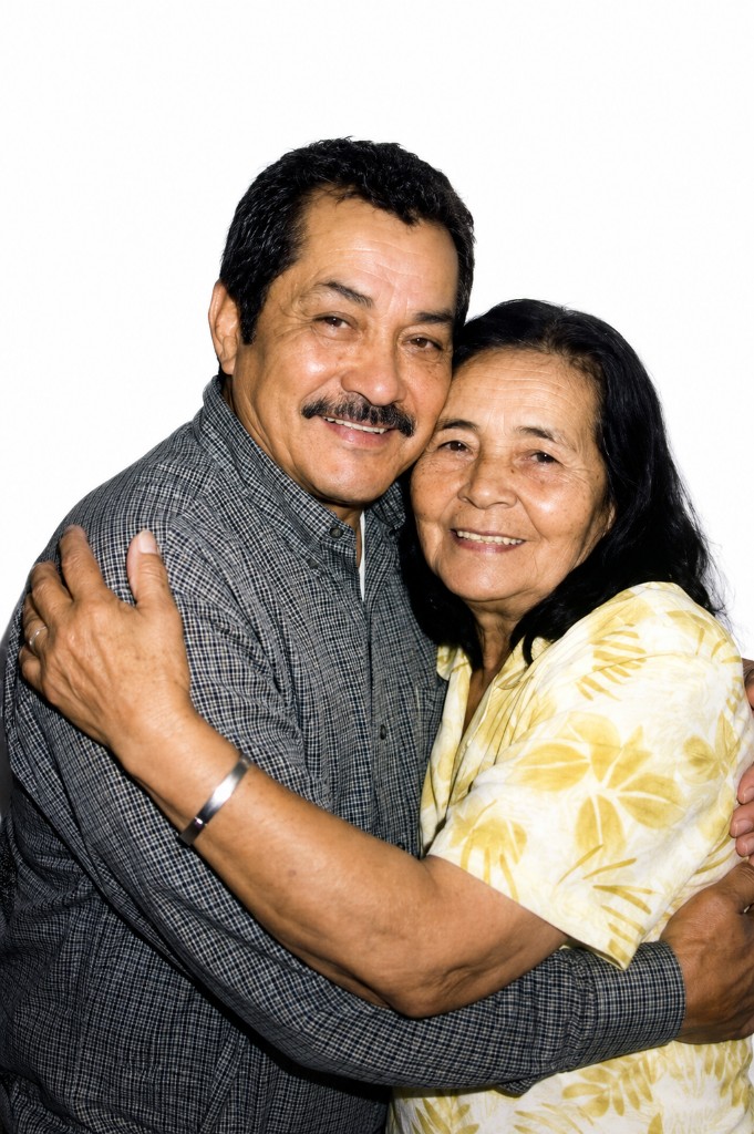 Pareja mayor sonriendo y abrazándose con cariño.