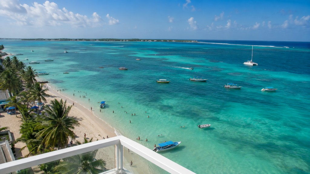 Vista desde un balcón a una playa tropical con agua turquesa y palmeras — 30 de agosto de 2026